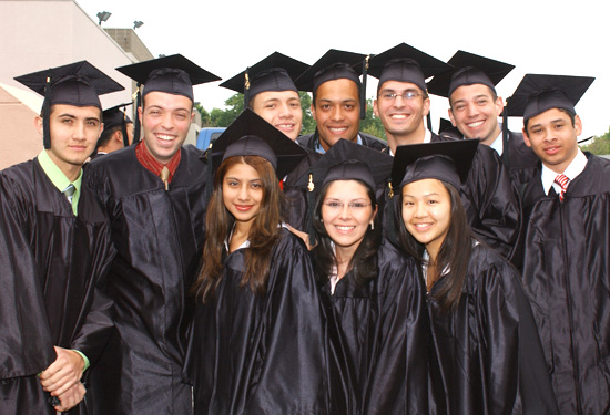 Recent graduates posing for a group shot all wearing their caps and gowns